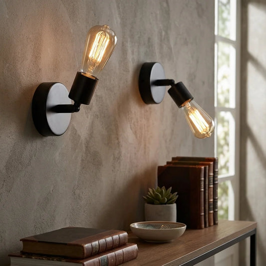 Two wall-mounted lights with vintage-style bulbs on a textured wall.