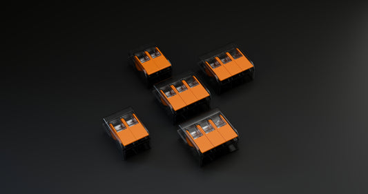 Compact transparent lever wire connectors with orange levers for fast electrical cable splicing and joining.