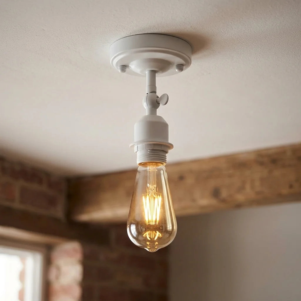 A white ceiling light fixture with a single clear glass Edison-style bulb, shown mounted on a textured ceiling with a wooden beam and brick wall in the background.