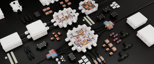 Overhead layout of spring lever connectors, push-fit wire terminals, and cable junction boxes on a dark surface.