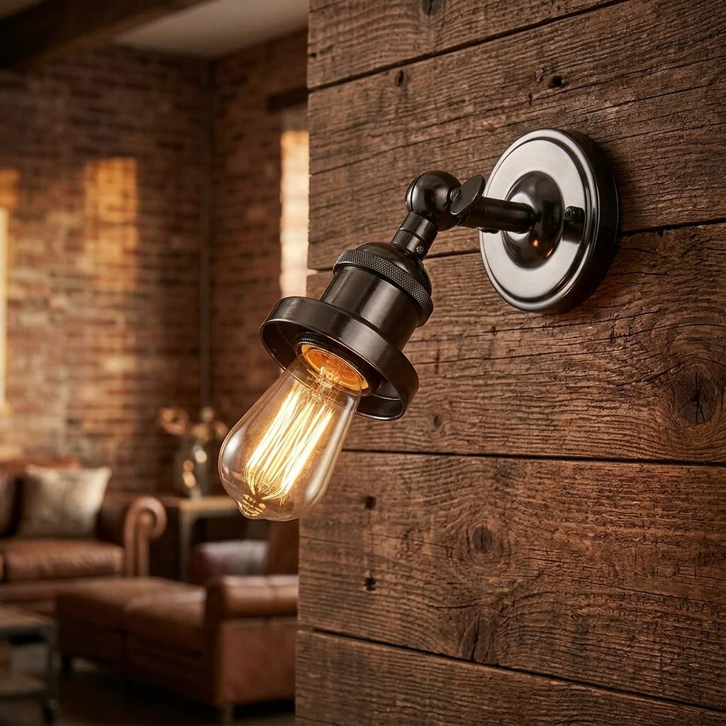 Industrial-style wall sconce with a black metal adjustable arm and a clear glass Edison bulb, mounted on a rustic dark wood plank wall in a warmly lit living room.