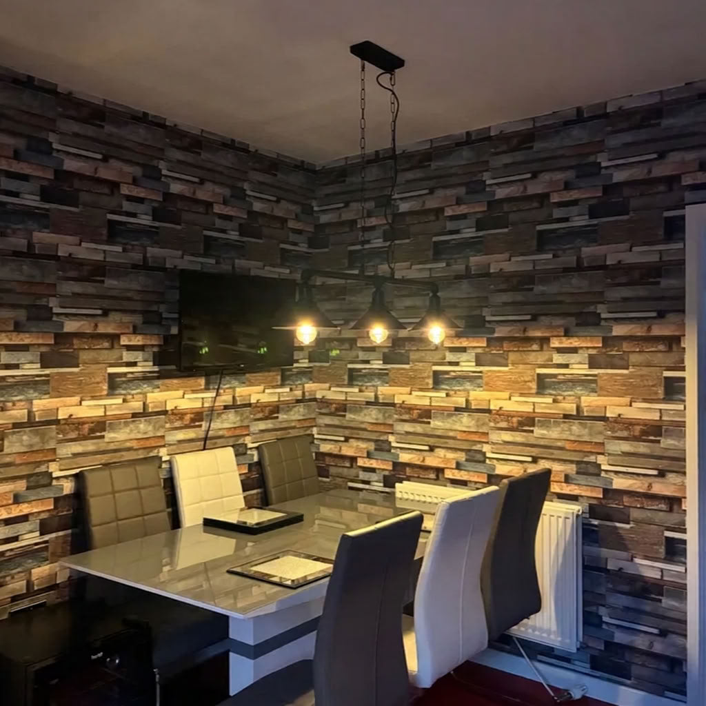 A dining room corner featuring a rustic multi-toned wood plank accent wall, a modern rectangular dining table, and several upholstered chairs under a multi-light pendant fixture. Customer review image