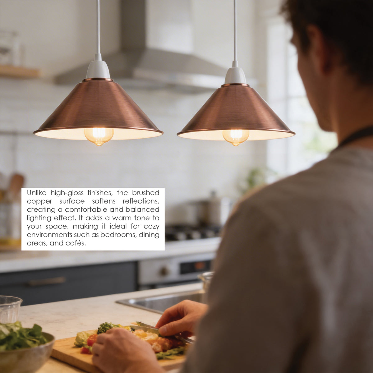 Two copper pendant lights hanging over a kitchen counter, with a person preparing food in the background. A text box on the left explains the brushed copper finish and warm lighting effect.