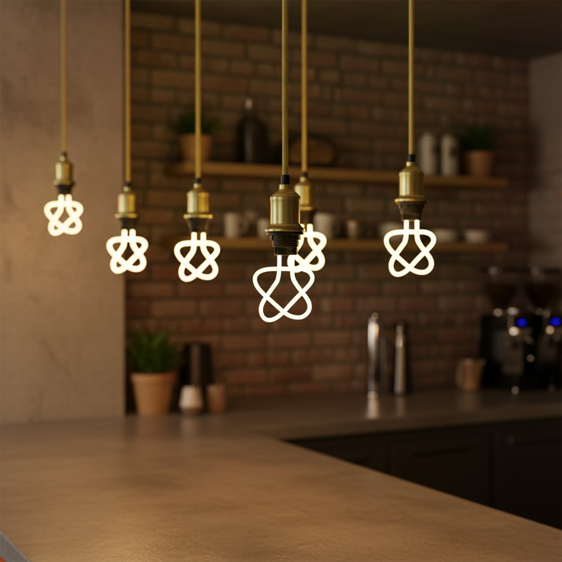 Decorative light bulbs hanging above a kitchen counter with a brick wall background.