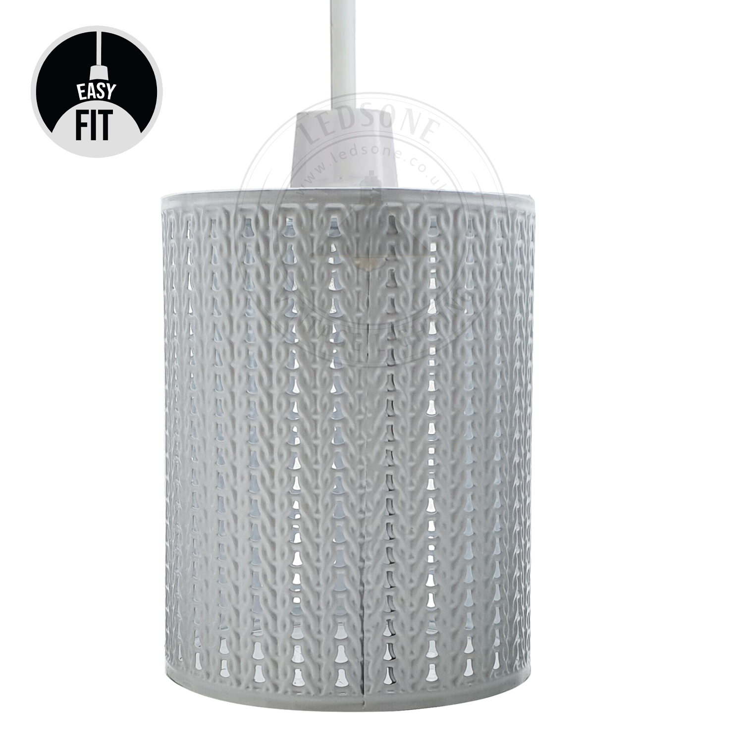 A metal cage lampshade pendant light fixture in a modern style, hanging in a room with a white wall and decorative plants.